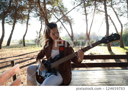 Girl Plays The Bass Among The Trees In The Countryside Girl Plays The Bass Among The Trees In The Countryside 124659783