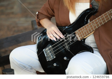 Girl Plays The Bass Instrument In The Countryside In Summer Girl Plays The Bass Instrument In The Countryside In Summer 124659786