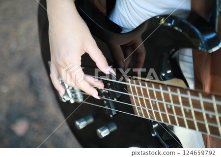 Hands Girl Plays Bass Musical Instrument In Mountains Among Trees Nature Hands Girl Plays Bass Musical Instrument In Mountains Among Trees Nature 124659792