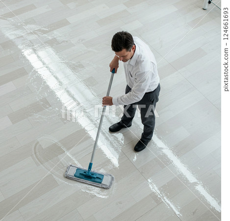 Male staff waxing the floor in the room 124661693