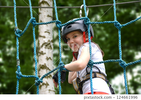 adventure climbing high wire park - people on course in mountain helmet and safety equipment. High quality photo adventure climbing high wire park - people on course in mountain helmet and safety equipment. High quality photo 124661996