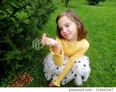 A beautiful teenage girl lying on green grass over sunlight. Eyes closed, enjoying nature outdoors. Cute teenage girl relaxing daydreaming in the park. Spring, summer, sunbathing. High quality photo 124662007