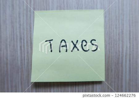 close up of word "taxes" written on the yellow memo paper with copy space 124662276