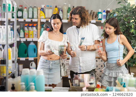 Family choosing toothbrush and toothpaste in hygiene aisle of supermarket 124662820