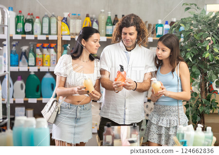 Family in summer clothes choosing hand soap in store Family in summer clothes choosing hand soap in store 124662836