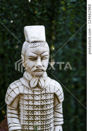 Terracotta army soldier statue standing guard in lush green garden Terracotta army soldier statue standing guard in lush green garden 124662968