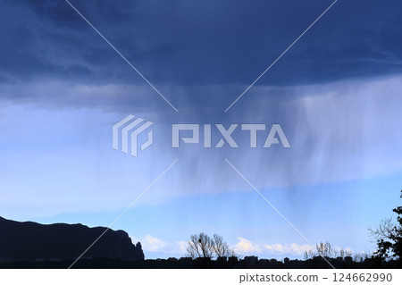 Rain falling from dark clouds over city and mountain landscape Rain falling from dark clouds over city and mountain landscape 124662990