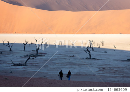 Two tourists walking at Deadvlei valley Two tourists walking at Deadvlei valley 124663609