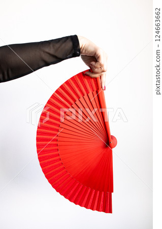 Hand holding red traditional fan against white background 124663662