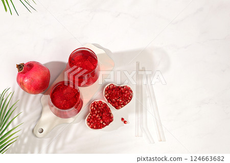 Fruit pomegranate juice and ingredients, summer pomegranate drink on bright table, detox diet and weight loss concept, healthy and natural food, source of vitamin C, selective focus, space for text. Fruit pomegranate juice and ingredients, summer pomegranate drink on bright table, detox diet and weight loss concept, healthy and natural food, source of vitamin C, selective focus, space for text. 124663682