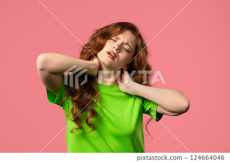 Tired young woman feeling pain in neck joint, massaging muscles, rubbing head. 124664046