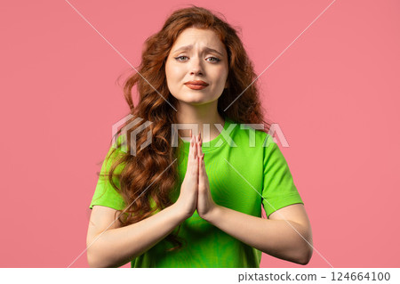 Woman praying, begs to apologize, she guilty. pink background. Hopeful prayer. Woman praying, begs to apologize, she guilty. pink background. Hopeful prayer. 124664100