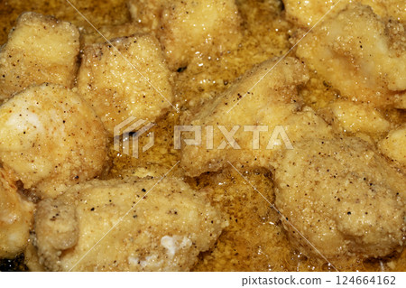 Close up of crispy frying chicken being fried in a batter in a pan 124664162