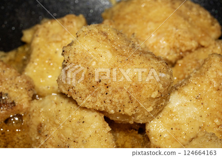 Close up of crispy frying chicken being fried in a batter in a pan Close up of crispy frying chicken being fried in a batter in a pan 124664163