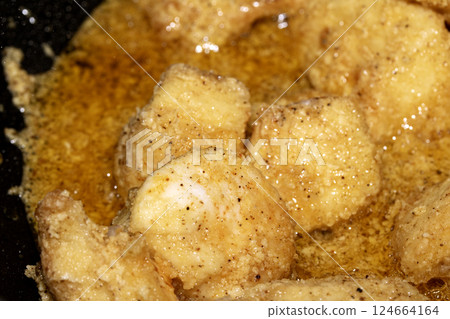 Close up of crispy frying chicken being fried in a batter in a pan Close up of crispy frying chicken being fried in a batter in a pan 124664164