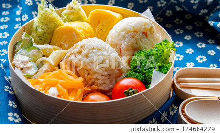 Open the furoshiki and put a handmade rice ball bento in a round box 124664279