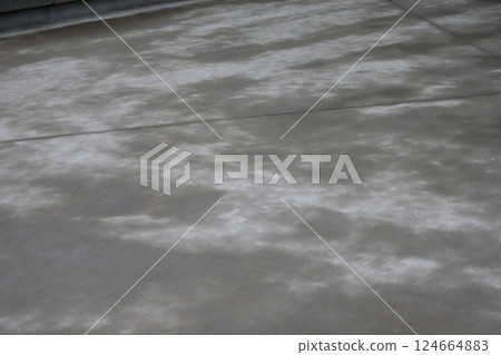 The surface of the concrete floor is damp from the rain. The surface of the concrete floor is damp from the rain. 124664883