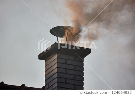 Smoking Chimney on a Roof 124664923