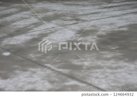 The surface of the concrete floor is damp from the rain. The surface of the concrete floor is damp from the rain. 124664932
