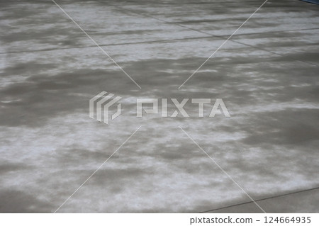 The surface of the concrete floor is damp from the rain. The surface of the concrete floor is damp from the rain. 124664935