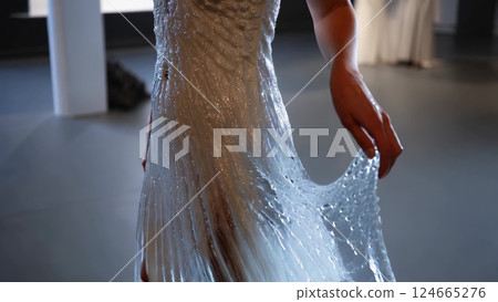Fashion designer showing innovative waterproof wedding dress 124665276