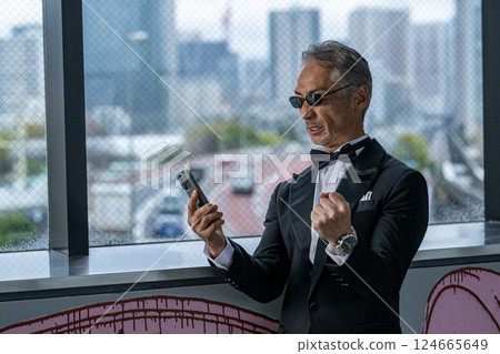 一位執行長在辦公大樓的辦公室裡透過電話發洩憤怒 一位執行長在辦公大樓的辦公室裡透過電話發洩憤怒 124665649