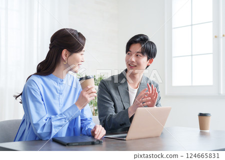 Businessmen and women having a meeting looking at a computer 124665831