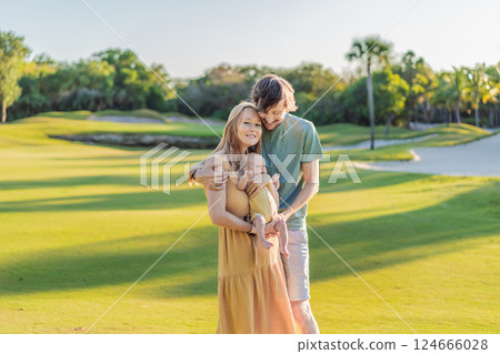 Loving parents with their newborn baby on a meadow in the park. Happy family enjoying nature, bonding, and peaceful outdoor moments. Parenthood, love, and family connection concept 124666028