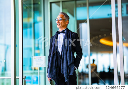 一位身著燕尾服的紳士透過自動門離開了設施。 124666277