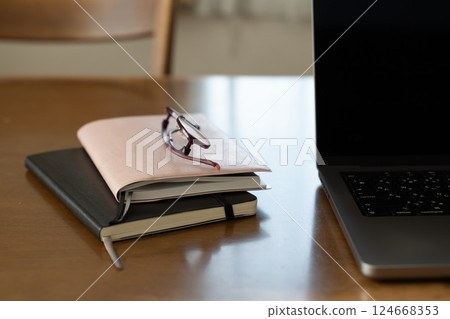 Two notebooks and a computer on a desk in the living room Two notebooks and a computer on a desk in the living room 124668353