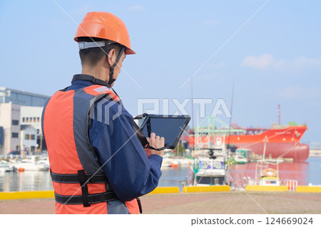 Back view of a male worker engaged in port work Back view of a male worker engaged in port work 124669024