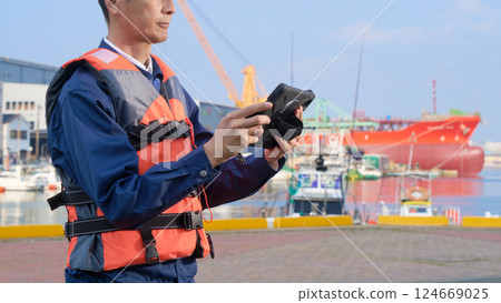 Male worker engaged in port work Male worker engaged in port work 124669025