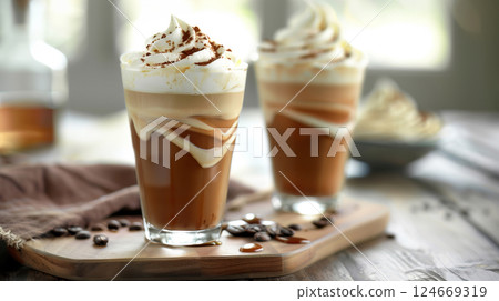 A tall glass of iced coffee with visible cream swirls, condensation on the glass, and coffee beans in the background. 124669319