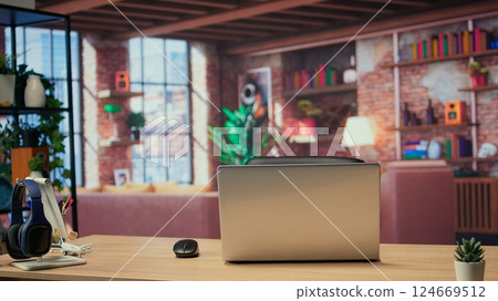High end modern apartment with a home office desk used for remote job, trendy urban loft decorated with stylish furniture and indoor plants. Empty studio space with wooden floors. 124669512