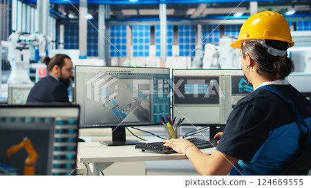 Solar panels manufacturing plant technician uses CAD program to optimize layouts. Photovoltaics factory staff member doing arrangements for maximum renewable energy output, camera A Solar panels manufacturing plant technician uses CAD program to optimize layouts. Photovoltaics factory staff member doing arrangements for maximum renewable energy output, camera A 124669555