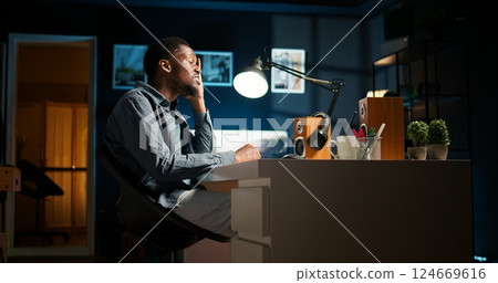 Researcher exhausted after working overtime to finish tasks on schedule. African American under pressure with stress from the leadership team, overcome major difficulties remotely. Camera A. 124669616