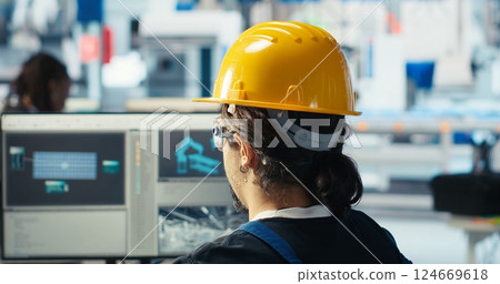 Photovoltaics factory engineer wearing yellow hardhat analyzing data, reviewing system metrics. Solar panels plant technician troubleshooting technical issues using computer software, camera B 124669618