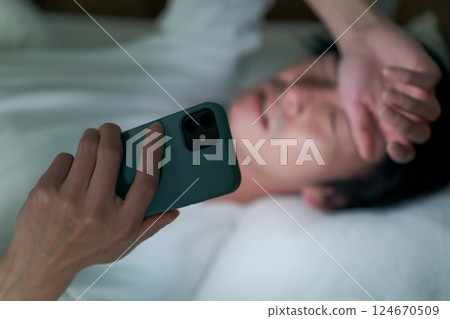 男人在床上看智能手機 男人在床上看智能手機 124670509