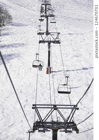Ski resort on a clear day: Lifts leading to the summit and white slopes Ski resort on a clear day: Lifts leading to the summit and white slopes 124670701