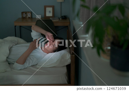 一名男子在床上使用智慧型手機 124671039