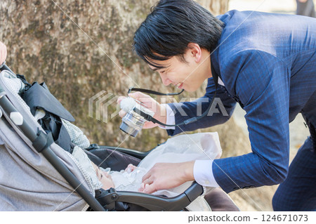 Dad taking a photo of his child at shrine visit 124671073
