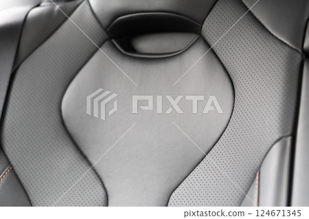 Back passenger black seats in modern luxury car. Black perforated leather with white stitching. Car details. Leather comfortable seats. Car interior details Back passenger black seats in modern luxury car. Black perforated leather with white stitching. Car details. Leather comfortable seats. Car interior details 124671345