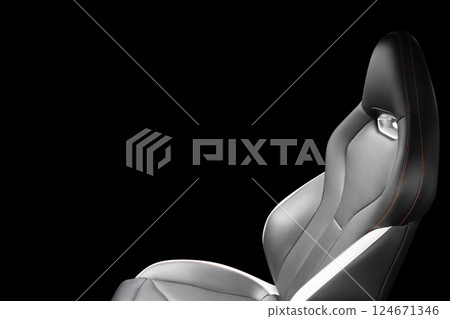 Black leather interior of the luxury modern car. Perforated black leather. Seats with stitching isolated on black background. Modern car interior details. Car inside 124671346
