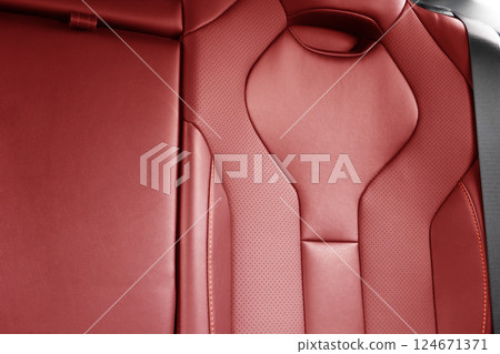 Back passenger red seats in modern luxury car. Red perforated leather with white stitching. Car details. Leather comfortable seats. Car interior details Back passenger red seats in modern luxury car. Red perforated leather with white stitching. Car details. Leather comfortable seats. Car interior details 124671371