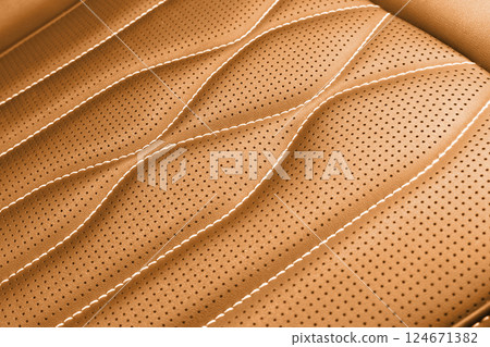 Modern luxury car brown leather interior. Part of brown leather car seat details with white stitching. Interior of prestige car. Comfortable perforated leather seats. Modern luxury car brown leather interior. Part of brown leather car seat details with white stitching. Interior of prestige car. Comfortable perforated leather seats. 124671382