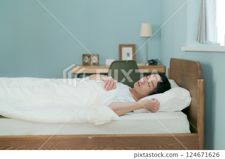 A man sleeping in bed A man sleeping in bed 124671626