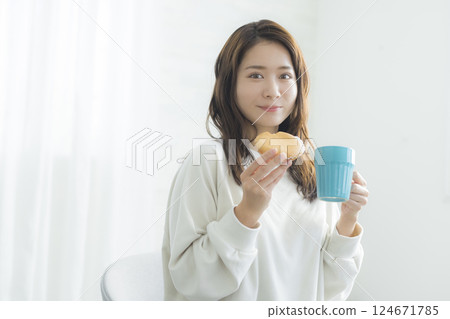 woman eating bread for breakfast woman eating bread for breakfast 124671785