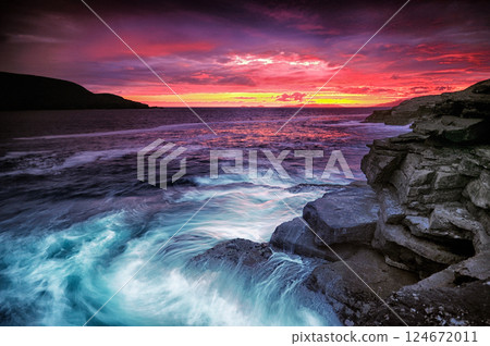 Long exposure landscape, dark colourful dramatic sunset, coast rugged rocks 124672011