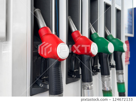 Gasoline and diesel distributor at the gas station. Gas pump nozzles. Petrol filling gun close-up at the gas station. Colorful Petrol pump filling nozzles. Fuel pump 124672133