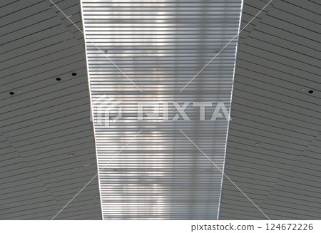 Lights and ventilation system in long line on ceiling of the industrial building. Exhibition Hall. Ceiling factory construction	Lights and ventilation system in long line on ceiling of the industrial 124672226